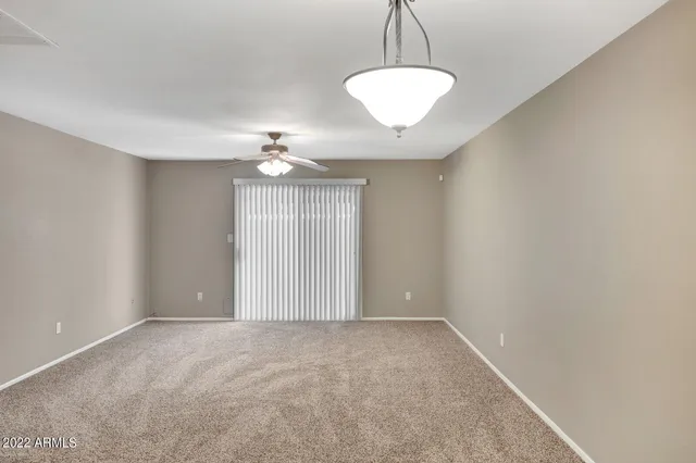 a view of an empty room with a ceiling fan