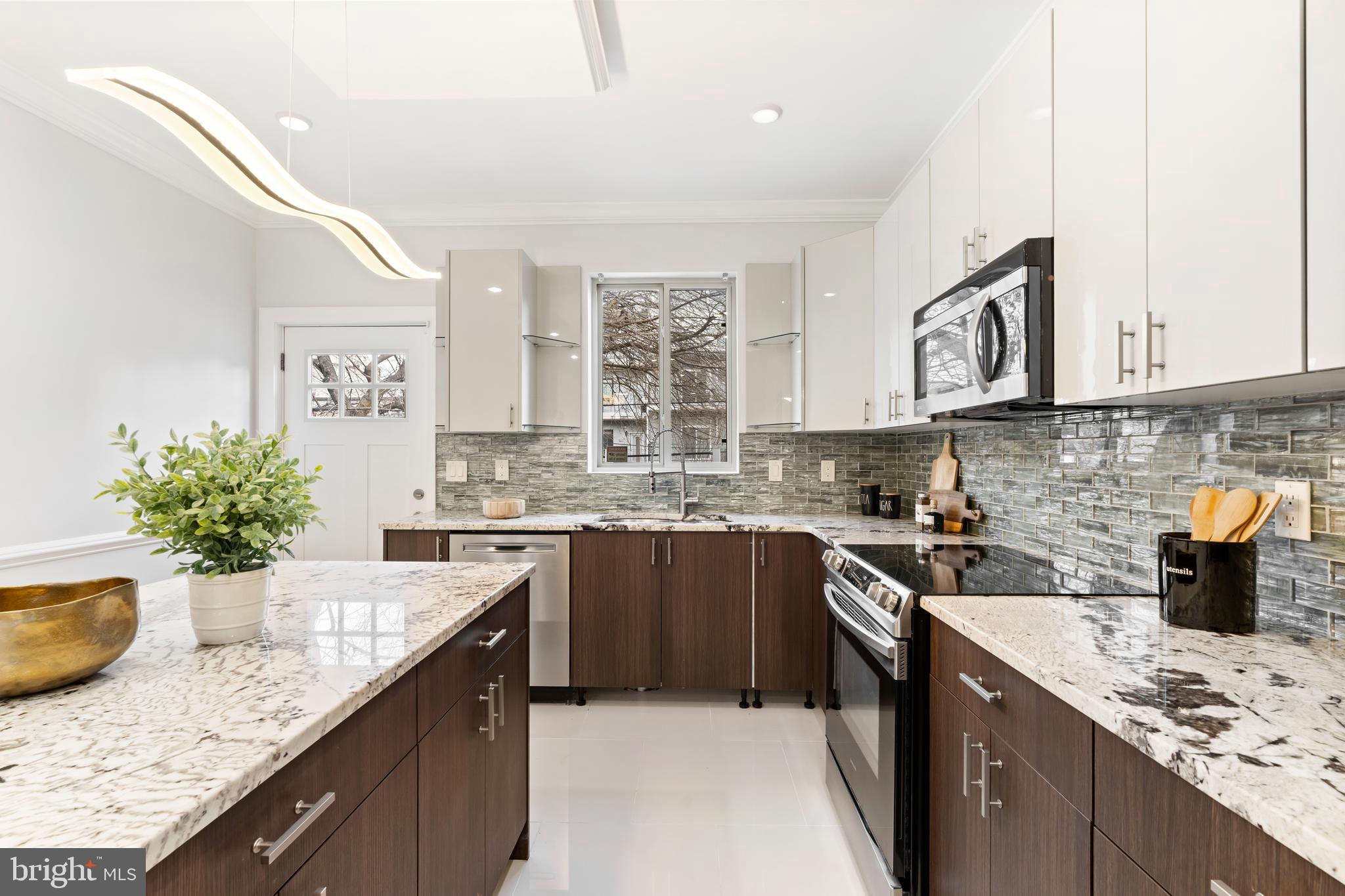 827 Leland Street Philadelphia, PA 19130 - Photo 12 of 40 a kitchen with stainless steel appliances granite countertop a sink stove and cabinets