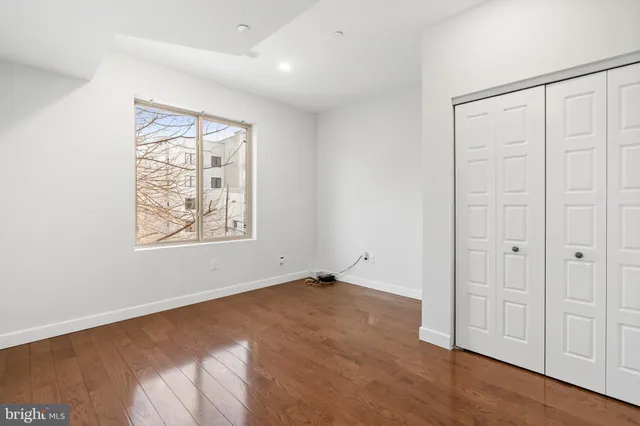 an empty room with windows and closet