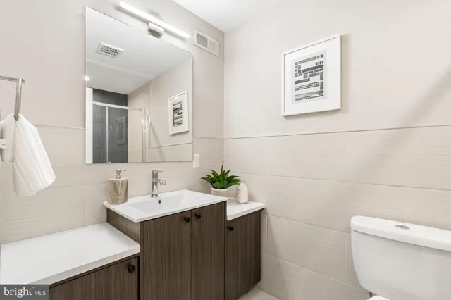 a bathroom with a toilet sink and mirror