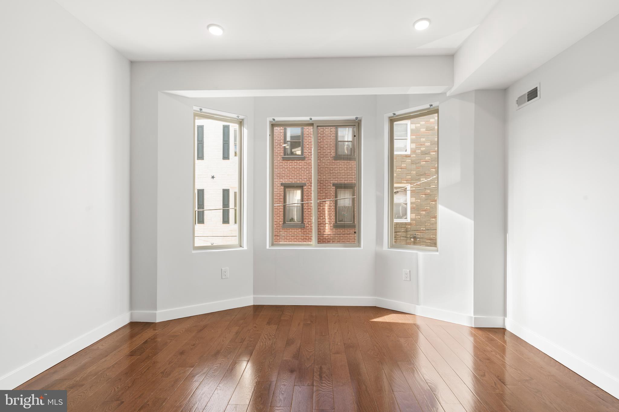 827 Leland Street Philadelphia, PA 19130 - Photo 17 of 40 an empty room with wooden floor and windows