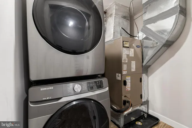 wooden floor in a utility room with washer and dryer