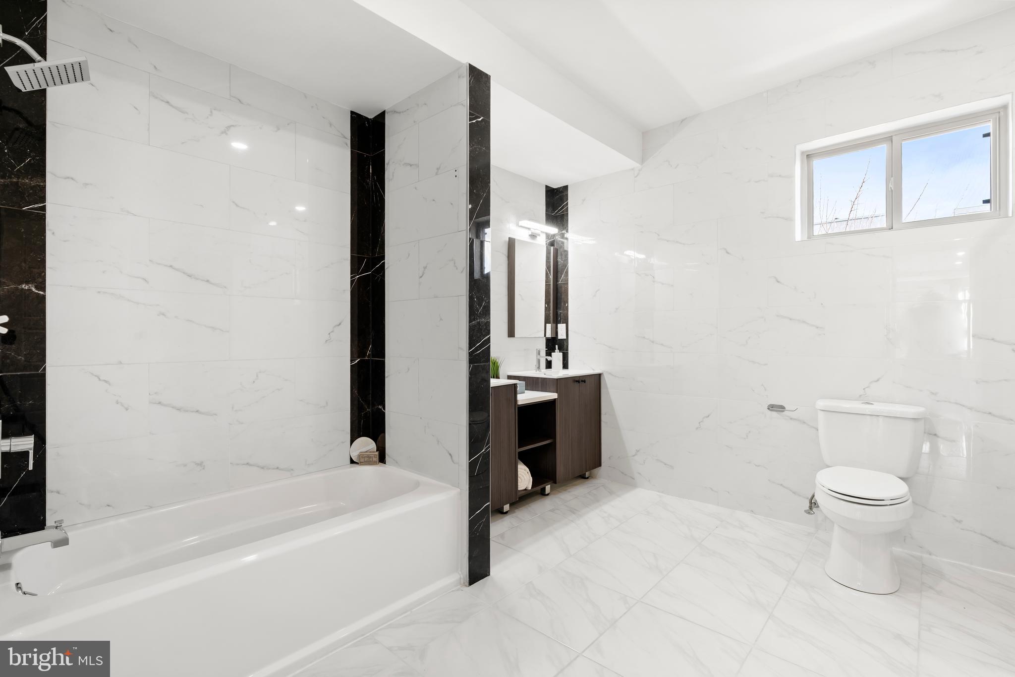 827 Leland Street Philadelphia, PA 19130 - Photo 24 of 40 a bathroom with a bathtub sink mirror and toilet