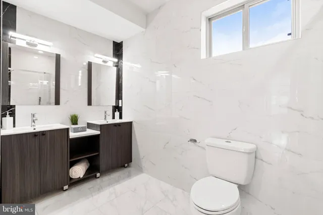 a bathroom with a toilet a sink and mirror