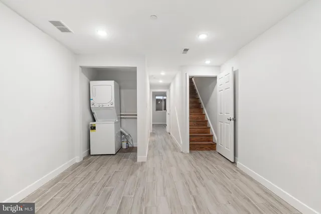 a view of a hallway with wooden floor and staircase