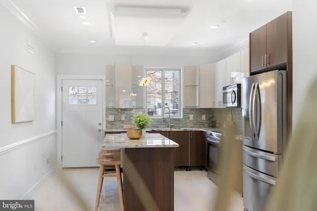 a kitchen with stainless steel appliances a refrigerator sink and white cabinets