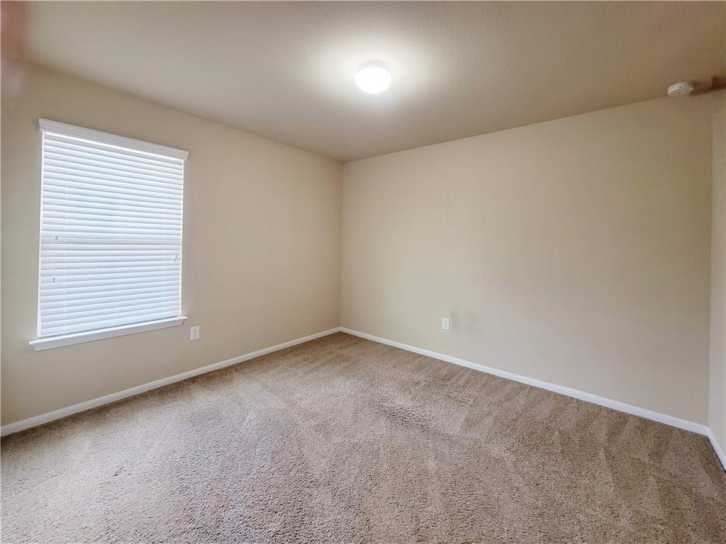 11924 Riparian Road Manor, TX 78653 - Photo 10 of 14 Empty room featuring light carpet and baseboards