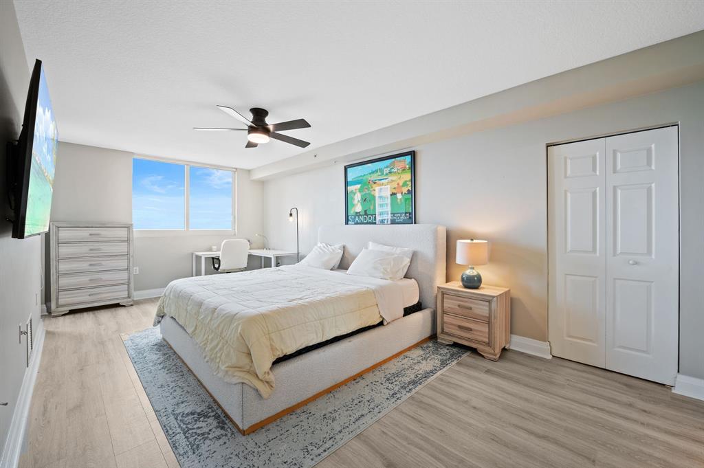 2011 North Ocean Boulevard, Unit 1605 Fort Lauderdale, FL 33305 - Photo 12 of 52 a spacious bedroom with a bed and a chandelier