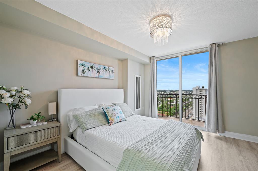 2011 North Ocean Boulevard, Unit 1605 Fort Lauderdale, FL 33305 - Photo 19 of 52 a bedroom with a large bed and a chandelier