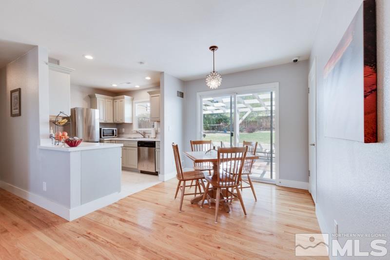 1695 Lander Street Reno, NV 89509 - Photo 14 of 38 a kitchen with a table chairs wooden floors and white stainless steel appliances