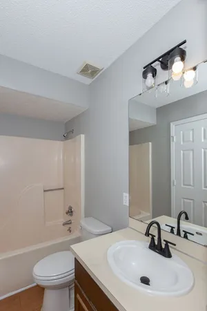 a bathroom with a sink a toilet and a mirror