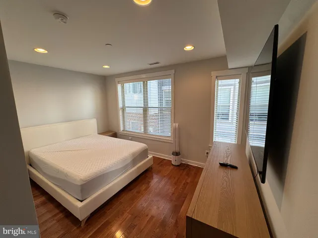 a bedroom with a bed and a large window