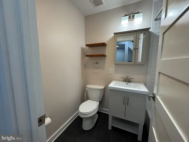 a bathroom with a toilet sink and mirror