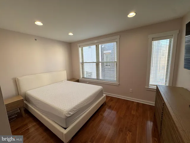a bed sitting in a spacious bedroom next to a window