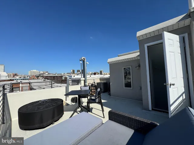 a view of roof deck with table and chairs