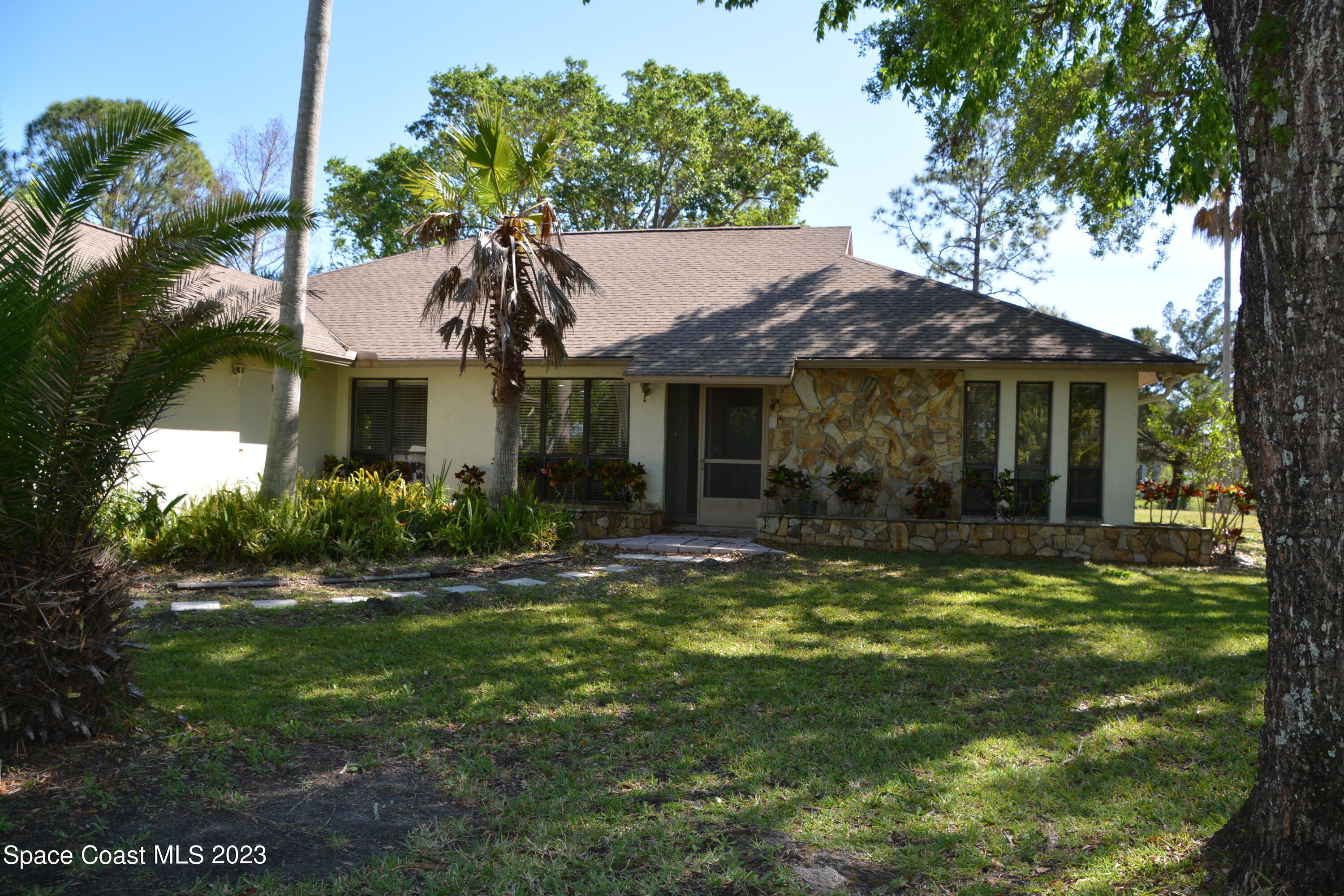 1045 Pine Island Road Merritt Island, FL 32953 - Photo 40 of 42 a front view of a house with a yard table and chairs