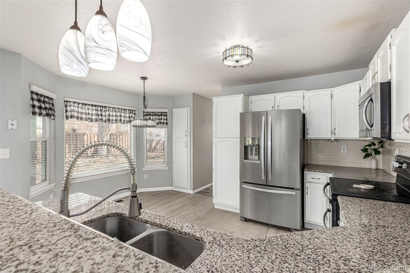 3623 West Rosewalk Circle Highlands Ranch, CO 80129 - Photo 15 of 44 a kitchen with a refrigerator sink and cabinets