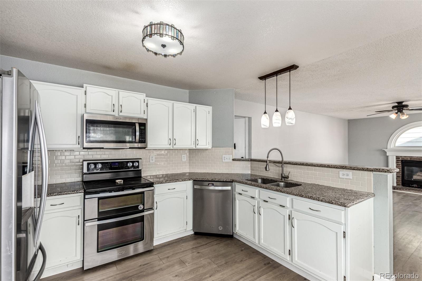 3623 West Rosewalk Circle Highlands Ranch, CO 80129 - Photo 18 of 44 a kitchen with a sink stainless steel appliances and white cabinets