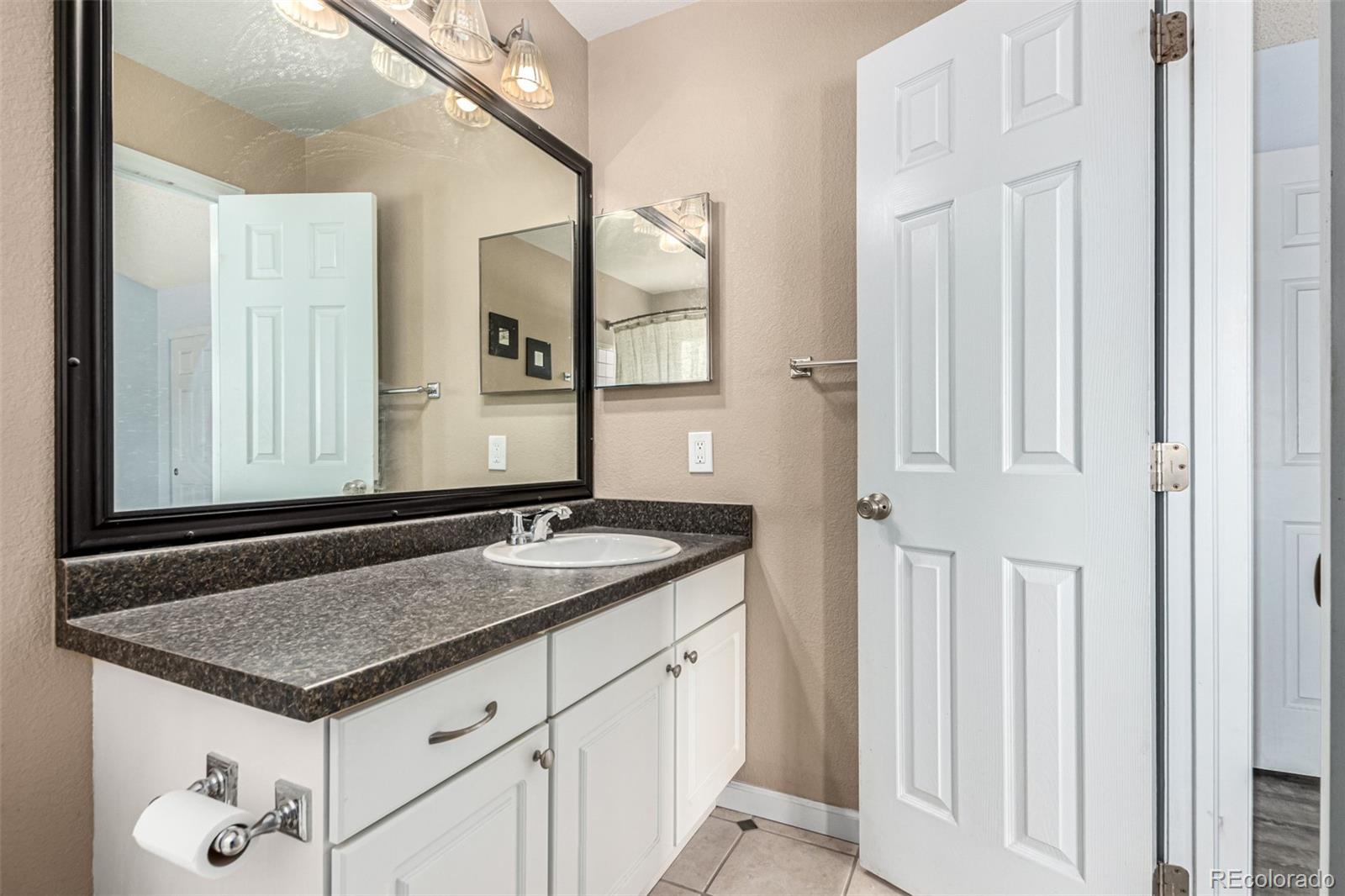 3623 West Rosewalk Circle Highlands Ranch, CO 80129 - Photo 26 of 44 a bathroom with a granite countertop sink and a mirror