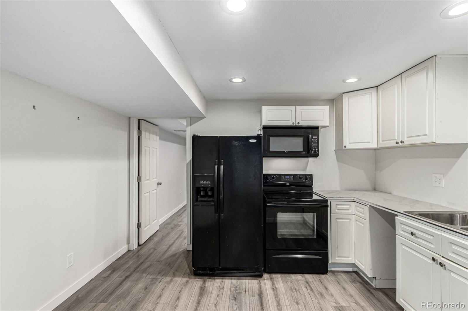 3623 West Rosewalk Circle Highlands Ranch, CO 80129 - Photo 32 of 44 a kitchen with a refrigerator and a stove top oven