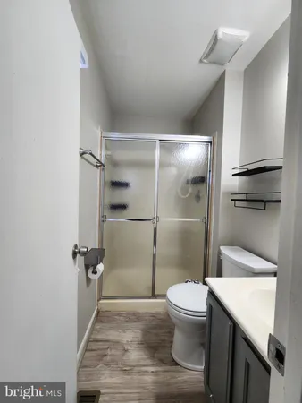 a bathroom with a granite countertop toilet a sink and a shower