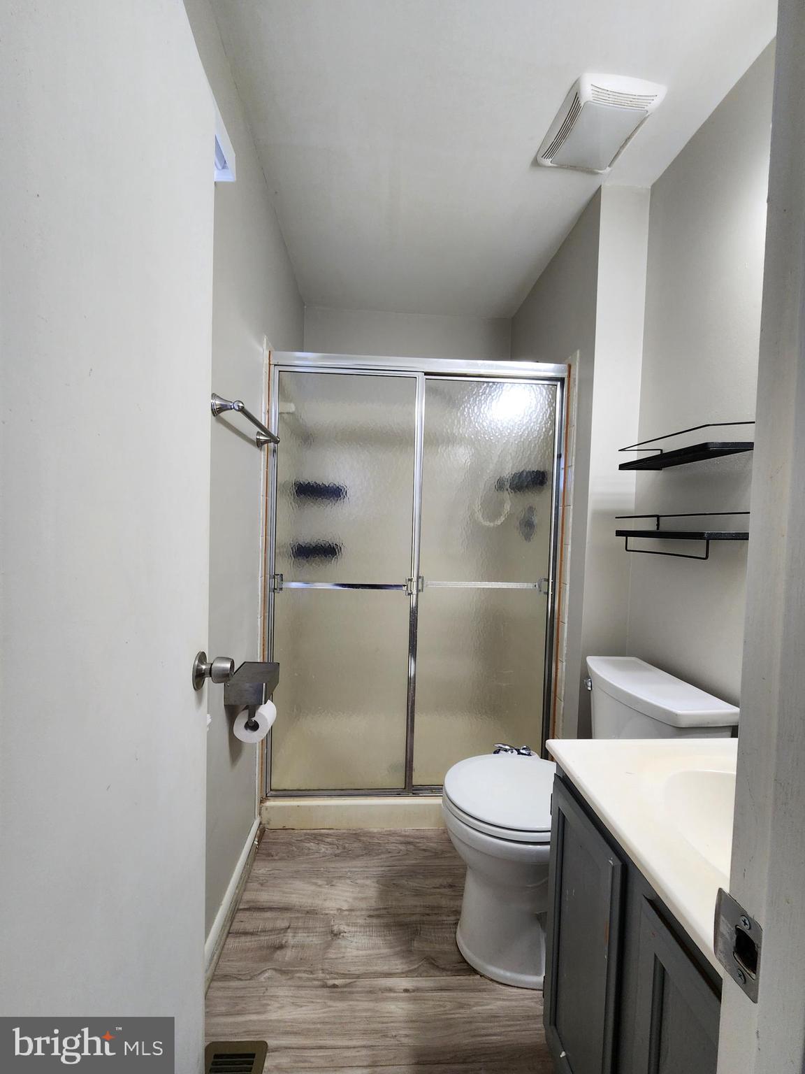 6660 Hunter Road Elkridge, MD 21075 - Photo 11 of 27 a bathroom with a granite countertop toilet a sink and a shower