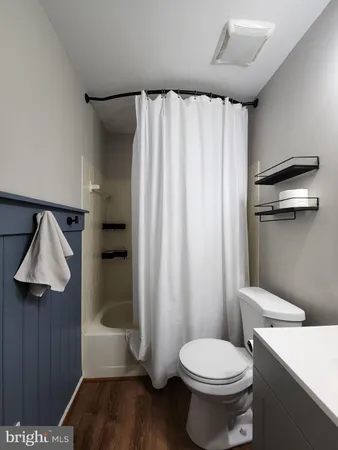 a white toilet sitting next to a shower curtain