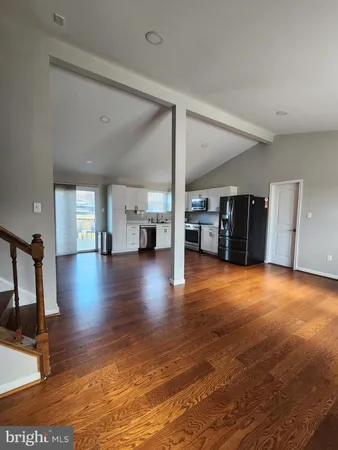 a view of empty room with wooden floor and windows