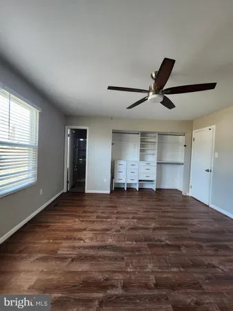 a view of an empty room with window and cabinet