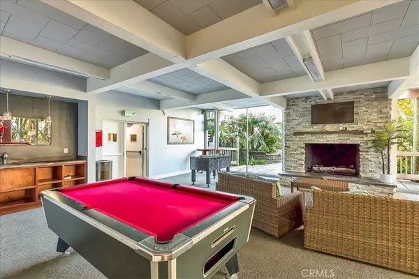 a room with pool table flat screen tv and windows