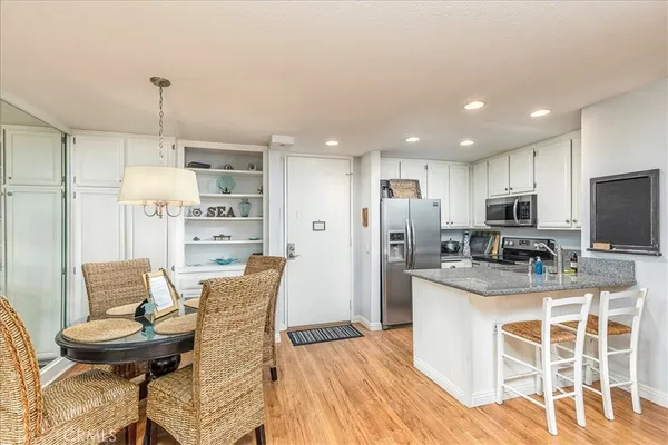 a kitchen with stainless steel appliances kitchen island granite countertop a refrigerator and a stove top oven