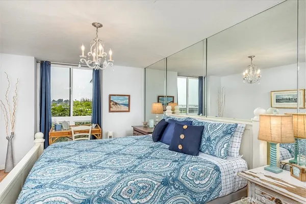 a bedroom with a large bed and a chandelier