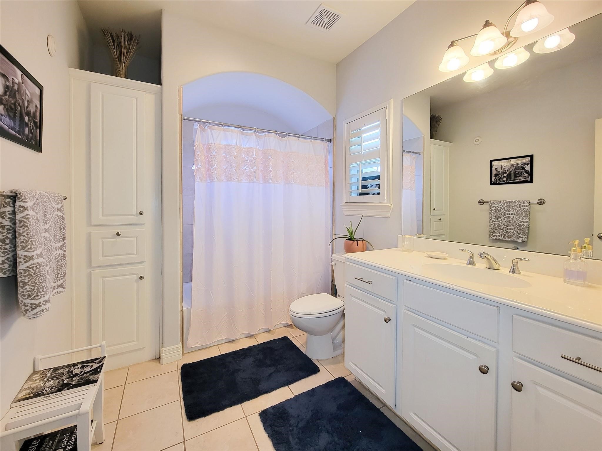 1421 Bremond Street Houston, TX 77004 - Photo 12 of 30 a spacious bathroom with a double vanity sink a toilet a mirror and shower