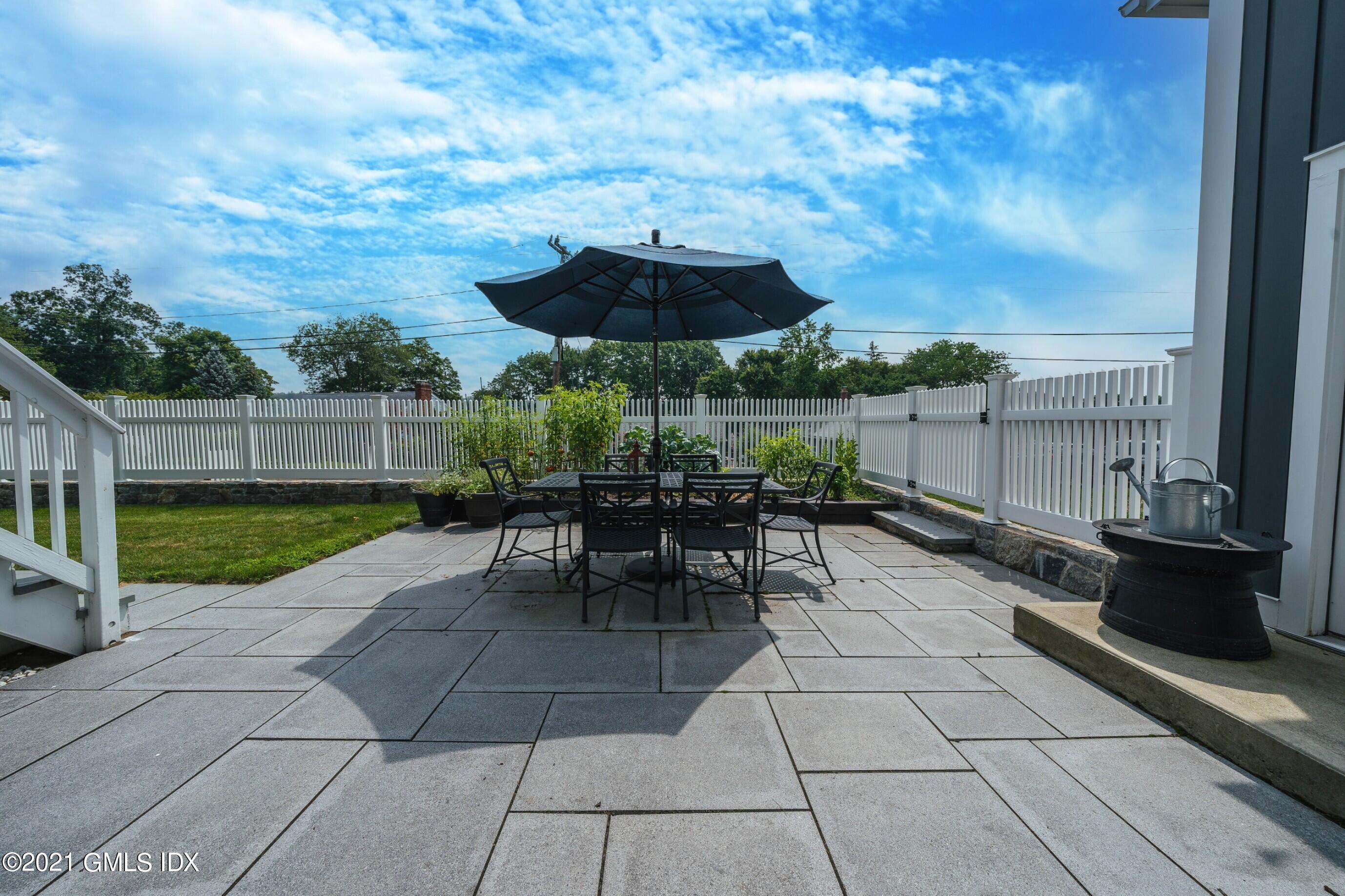 47 Cognewaugh Road Cos Cob, CT 06807 - Photo 27 of 44 a view of a patio with a table and chairs under an umbrella