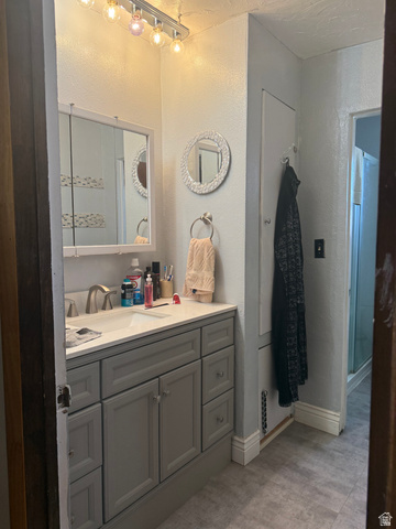 665 Molen Road Ferron, UT 84523 - Photo 9 of 21 Full bath with a textured wall, vanity, a shower, and light tile patterned floors