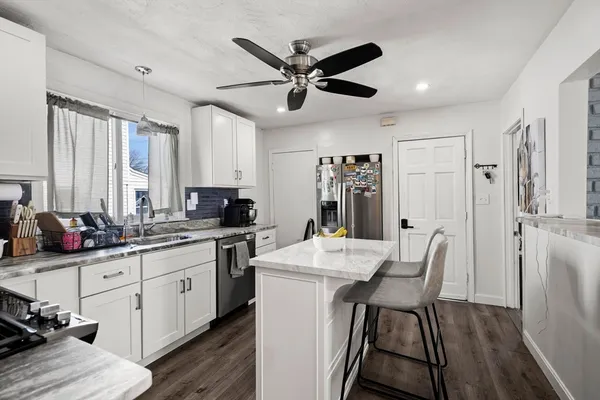 a kitchen with a table chairs refrigerator and cabinets