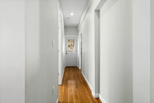 a view of a hallway with wooden floor