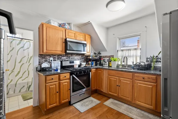 a kitchen with stainless steel appliances a stove a sink and a microwave