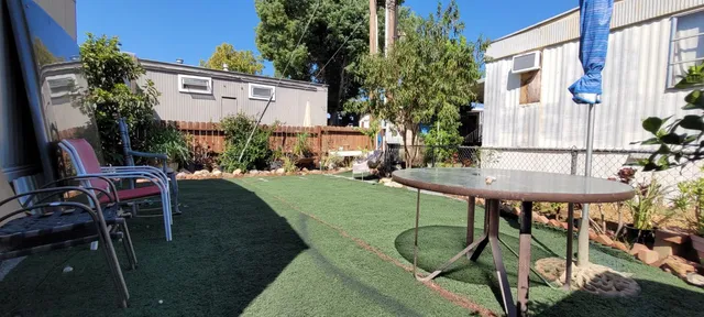 a view of a chairs and table in backyard of the house
