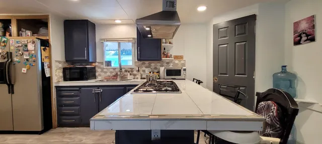 a kitchen with a table chairs refrigerator and cabinets
