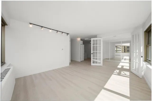 a view of a big room with closet and windows