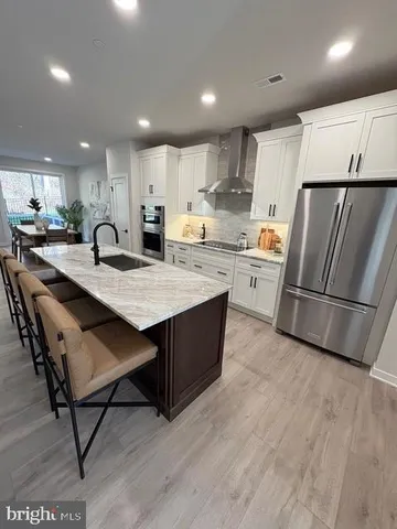 a large kitchen with kitchen island a large counter top space a sink appliances and cabinets