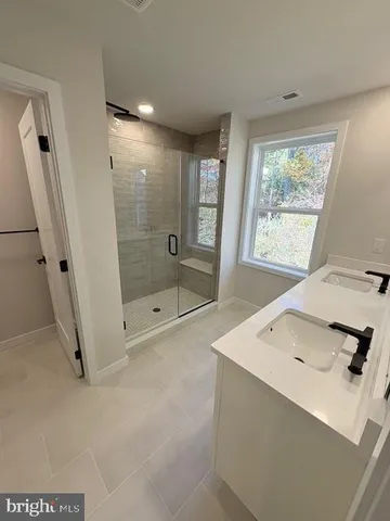 a bathroom with a sink a mirror and a shower