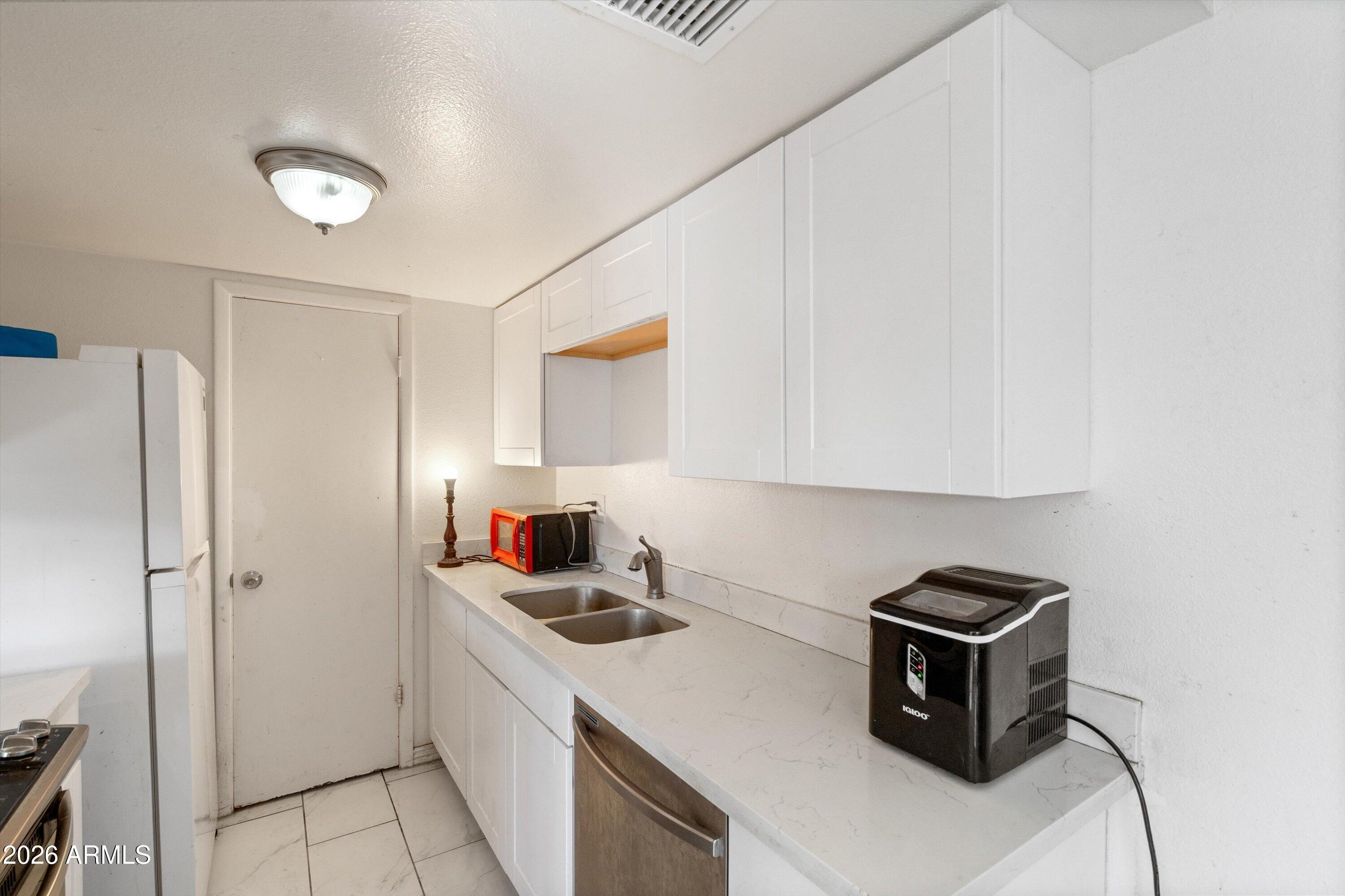 600 South Dobson Road, Unit 88 Mesa, AZ 85202 - Photo 14 of 18 a kitchen with a refrigerator sink and cabinets