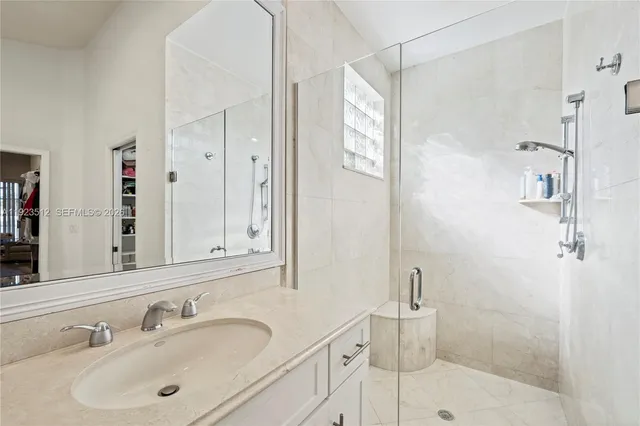 a bathroom with a shower sink and mirror