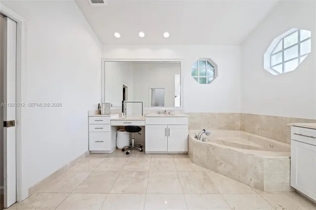 a bathroom with a tub sink and mirror