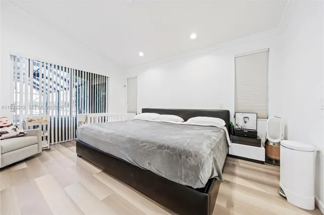 a bedroom with a bed and a large window