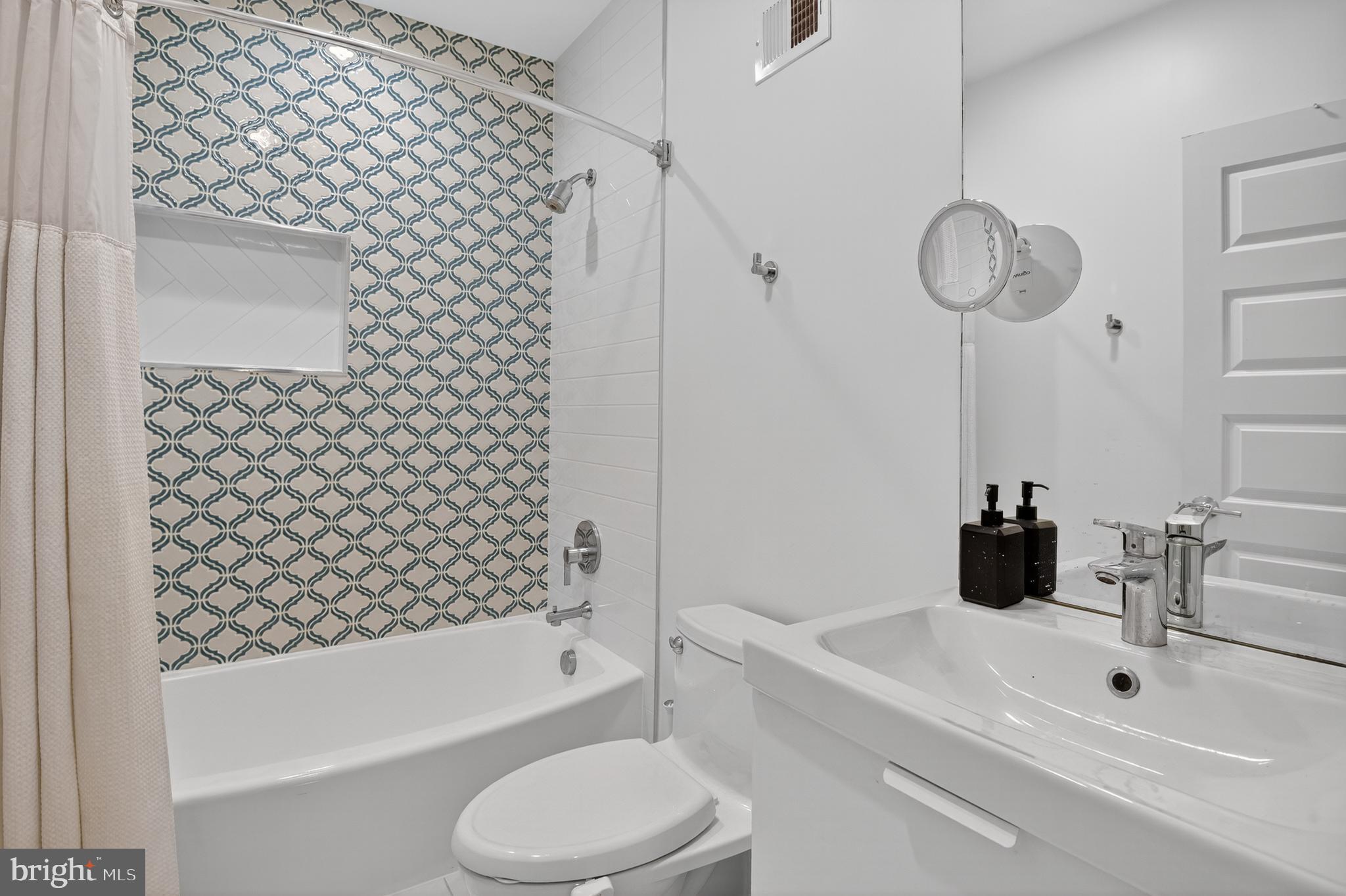 3911 Kansas Avenue Northwest, Unit 2 Washington, DC 20011 - Photo 29 of 46 a bathroom with a bathtub shower sink vanity and toilet