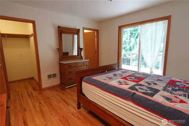 a room with a bed and a flat tv screen on a dresser