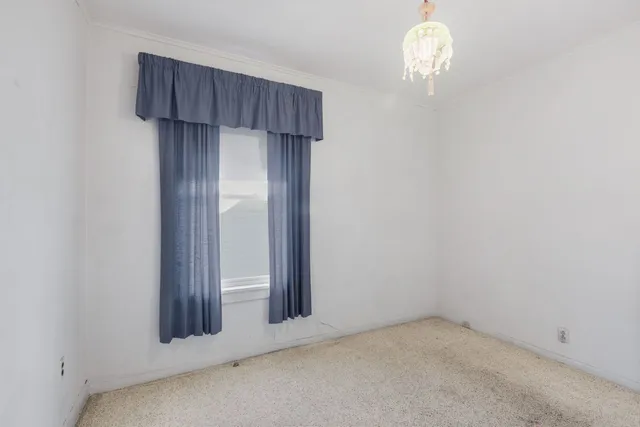 an empty room with wooden floor and a window